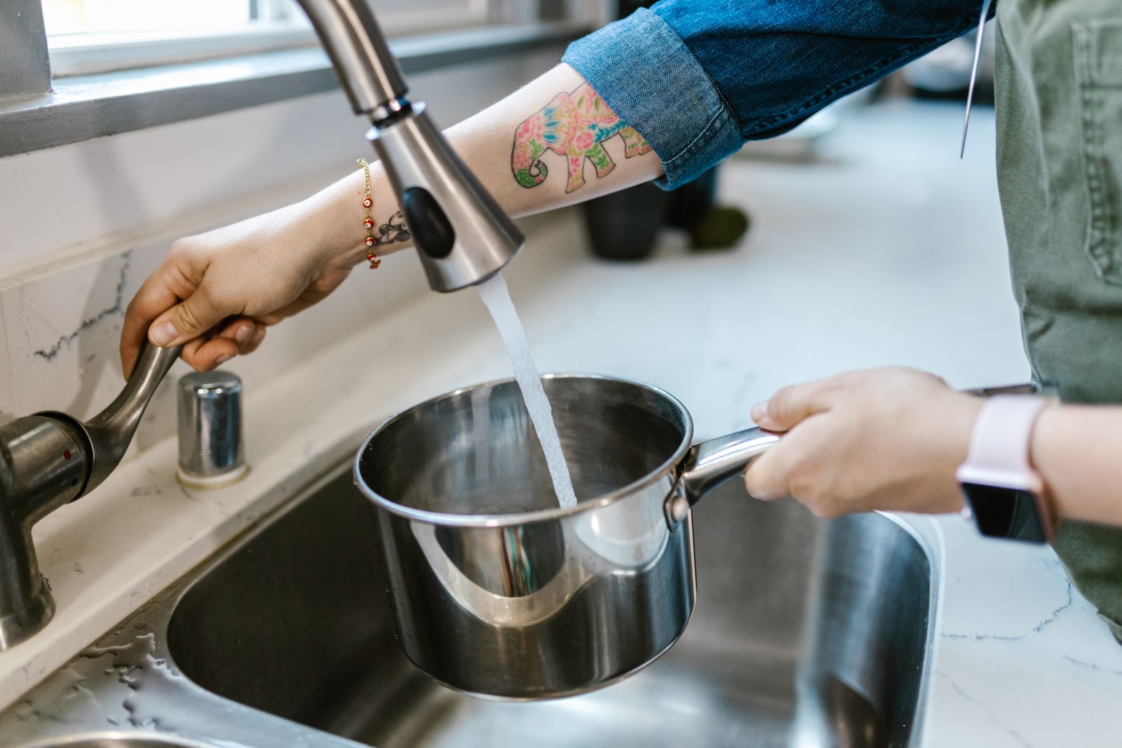 Modern sink sprayer rinsing cookware for choosing cleaning tablet or tool