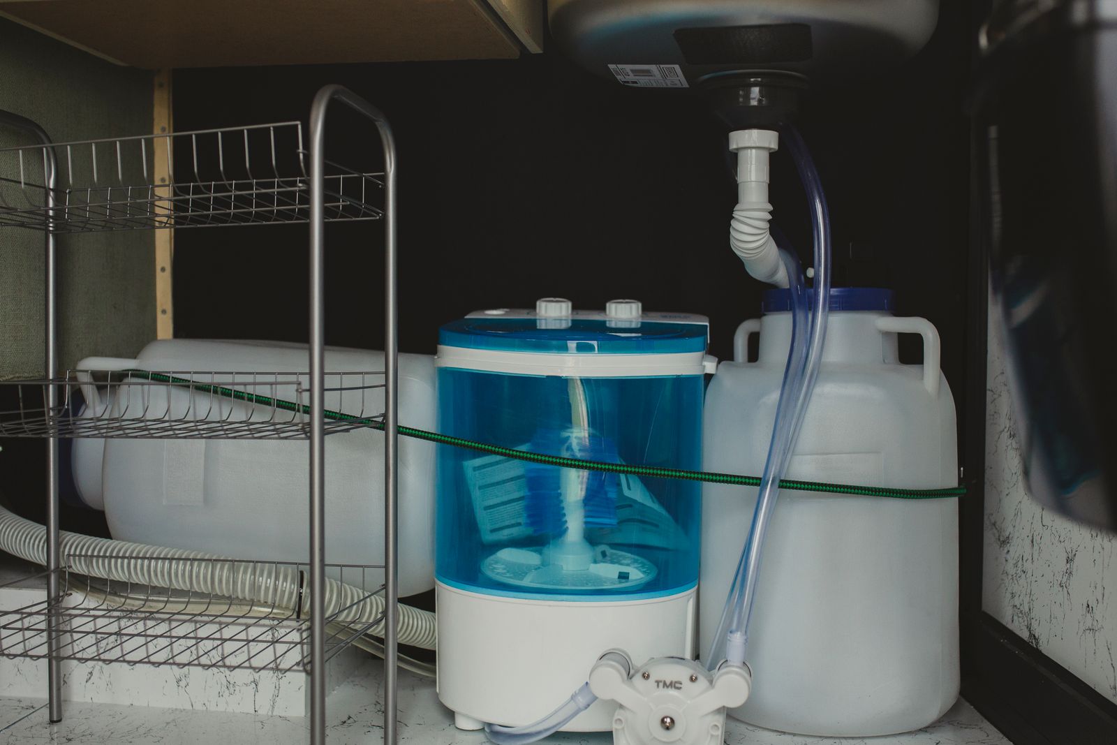Under sink cabinet with pipes and filters for odor residue and tight gap cleaning