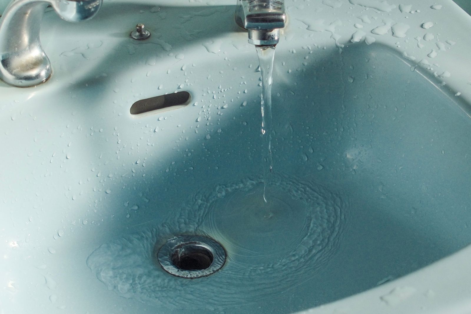 Water running into a sink drain for cleaning tablet instead of scrubbing
