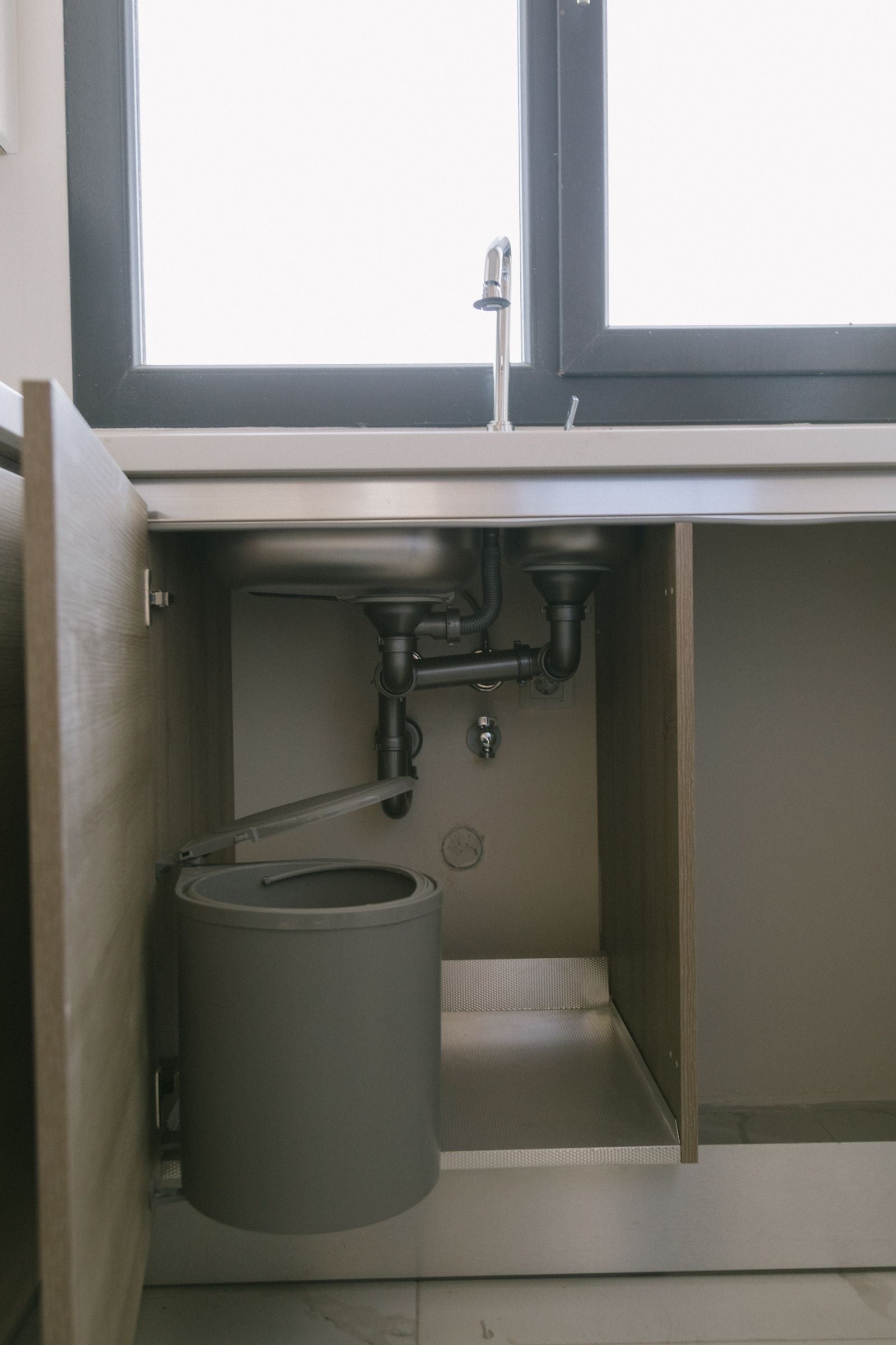 Modern under sink cabinet gap area for cleaning around appliances